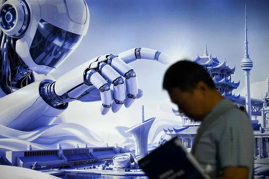 A man stands next to a poster of a humanoid robot during the China International Supply Chain Expo (CISCE) in Beijing on 25 June 2026.