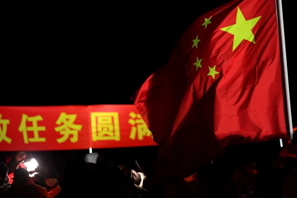 A Chinese flag is seen at the landing site of the return module of China's Chang'e-5 lunar probe in Siziwang Banner, in northern China's Inner Mongolia Autonomous Region on 17 December 2020. (STR/AFP)