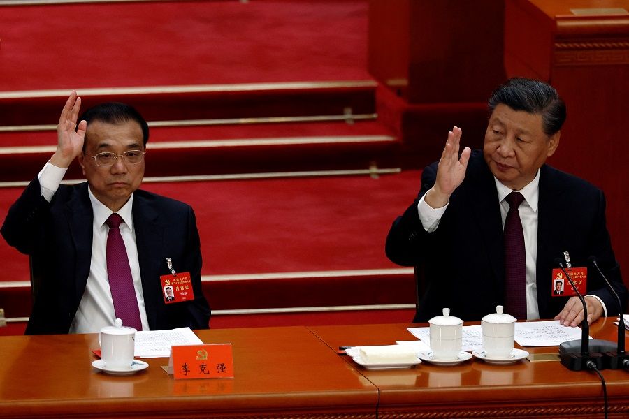 Chinese President Xi Jinping (right) and Chinese Premier Li Keqiang vote during the closing ceremony of the 20th Party Congress of the Communist Party of China, at the Great Hall of the People in Beijing, China, 22 October 2022. (Tingshu Wang/Reuters)
