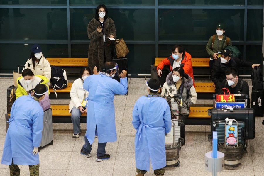 A group of Chinese tourists are led by South Korean soldiers wearing personal protective equipment as they wait for Covid-19 tests upon their arrival at the Incheon International Airport in Incheon, South Korea, 4 January 2023. (Kim Hong-Ji/Reuters)