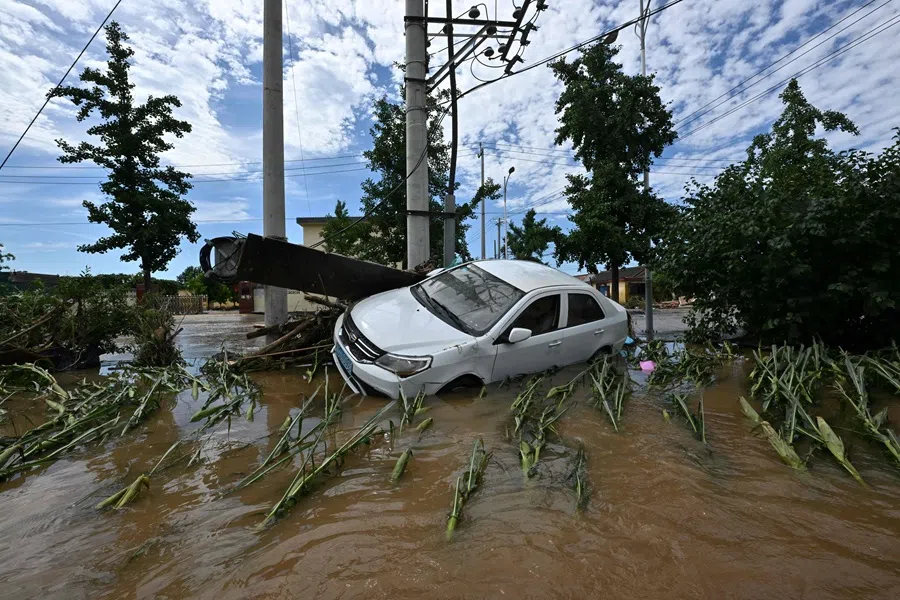 A damaged car is seen in a flooded neighbourhood in Miyun district, Beijing, China, on 29 July 2025. (Adek Berry/AFP)