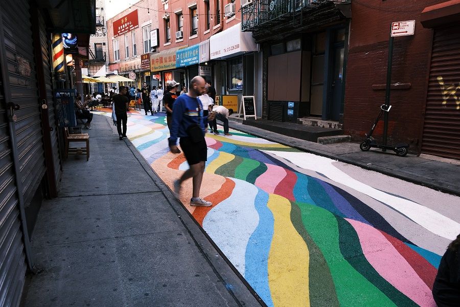 People pose for photos on the historic Doyers Street in Chinatown that has been painted over by Chilean-born street artist Dasic Fernandez, 24 June 2021 in New York City, US. (Spencer Platt/Getty Images/AFP)