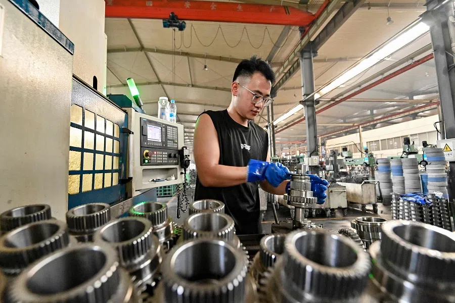 A worker sorts parts at a factory producing tractors in Qingzhou, in China’s eastern Shandong province on 15 August 2024. (AFP)