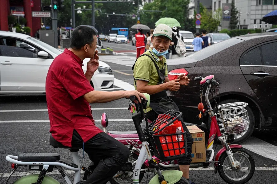 People wait for traffic lights along a street in Beijing, China, on 21 June 2024. (Jade Gao/AFP)