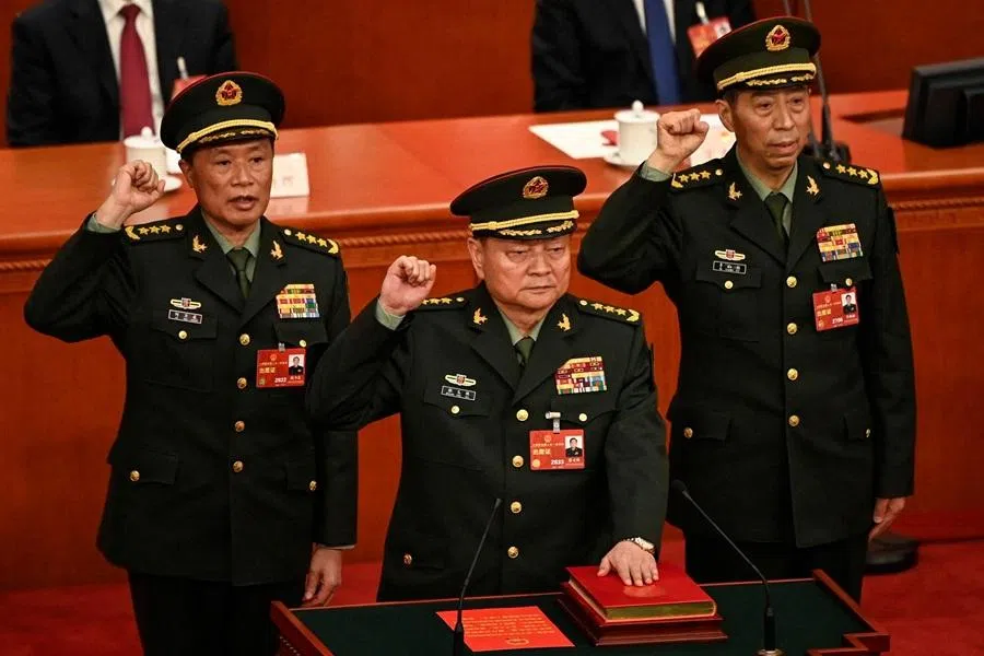 Zhang Youxia (centre), newly-elected vice-chairman of the Central Military Commission (CMC), swears an oath with members of the CMC He Weidong (left) and Li Shangfu (right) after they were elected during the fourth plenary session of the National People's Congress (NPC) at the Great Hall of the People in Beijing on 11 March 2023. (Greg Baker/Pool/AFP)