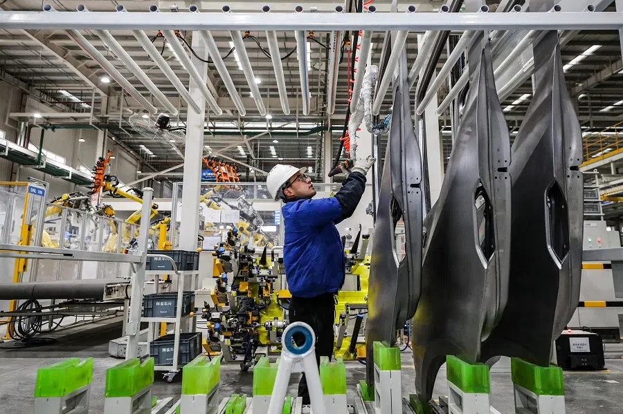 This photo taken on 21 February 2024 shows an employee working on a new energy vehicle assembly line at a BYD factory in Huai’an, Jiangsu province, China. (AFP)