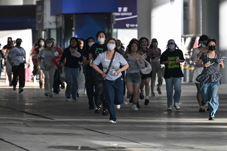 Fans run to try to see US rapper and producer Kanye West at Shanghai Pudong International Airport on 11 July 2025. (Hector Retamal/AFP)