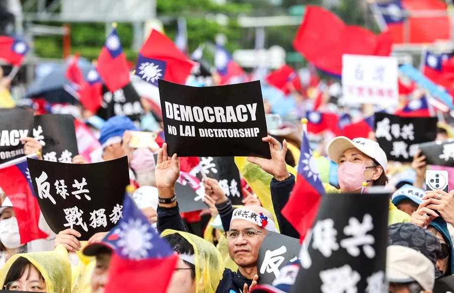 Protesters hold signs during a rally organised by the main opposition party (KMT) against Taiwan President Lai Ching-te in Taipei, Taiwan on 26 April 2025. (I-Hwa Cheng/AFP)