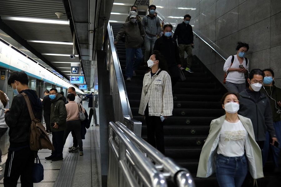 People walk inside a subway station during morning rush hour amid the Covid-19 outbreak in Beijing, China, 6 May 2022. (Tingshu Wang/Reuters)