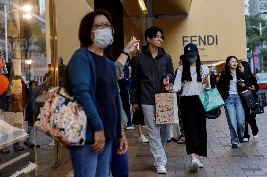 People walk along a street in Tsim Sha Tsui, a bustling shopping hotspot, in Hong Kong, China, on 5 December 2023. (Tyrone Siu/Reuters)