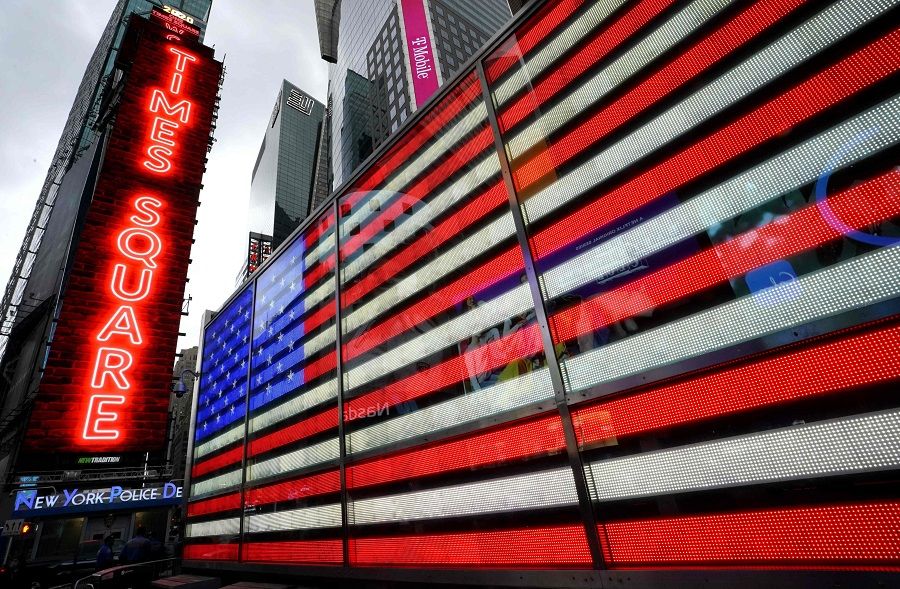 A neon sign of the American flag and neon lights at One Times Square in New York, 31 July 2020. (Timothy A. Clary/AFP)