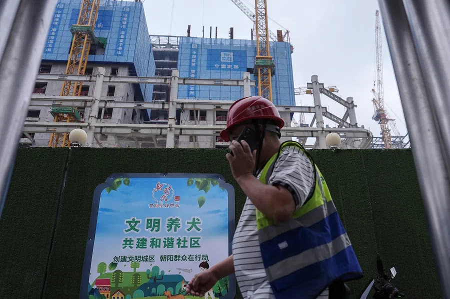 A worker walks past a construction site in Beijing’s central business district, China, on 14 July 2024.  (Tingshu Wang/Reuters)