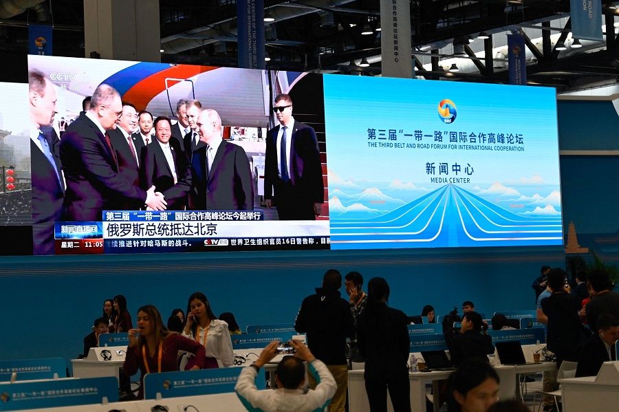 A screen in the media centre for the Belt and Road Forum shows news coverage of Russian President Vladimir Putin arriving at Beijing Capital International Airport on 17 October 2023. (Pedro Pardo/AFP)