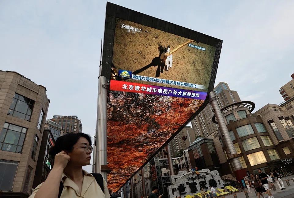 A large screen shows news footage of China’s Chang’e-6 lunar probe collecting a sample from the far side of the moon, in Beijing, China, 4 June 2024.  (Tingshu Wang/Reuters)