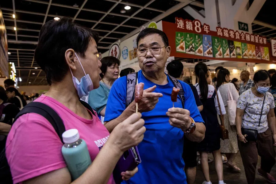 People eat food at a food expo at the Hong Kong Convention and Exhibition Centre on 18 August 2023. (Isaac Lawrence/AFP)
