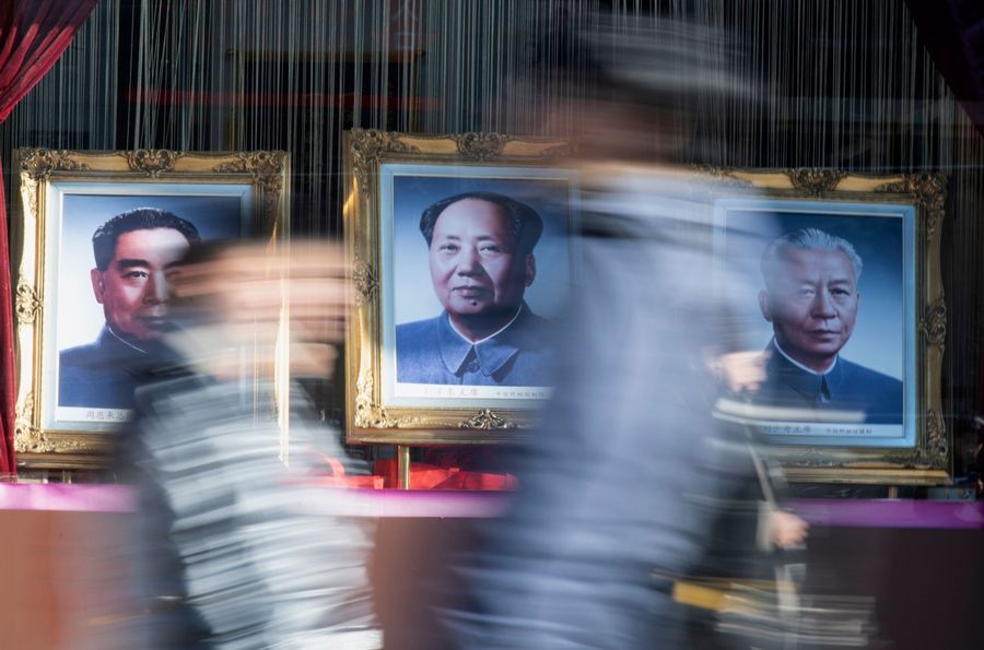 Is there life after death? In this photo, people walk past a picture of Mao Zedong in Beijing on 14 December 2019. (Noel Celis/AFP)