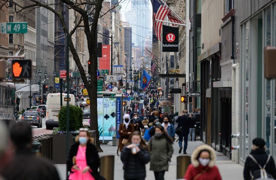 In this file photo taken on 2 April 2021, people walk on a busy 5th Avenue in midtown Manhattan, New York City, US. (Angela Weiss/AFP)