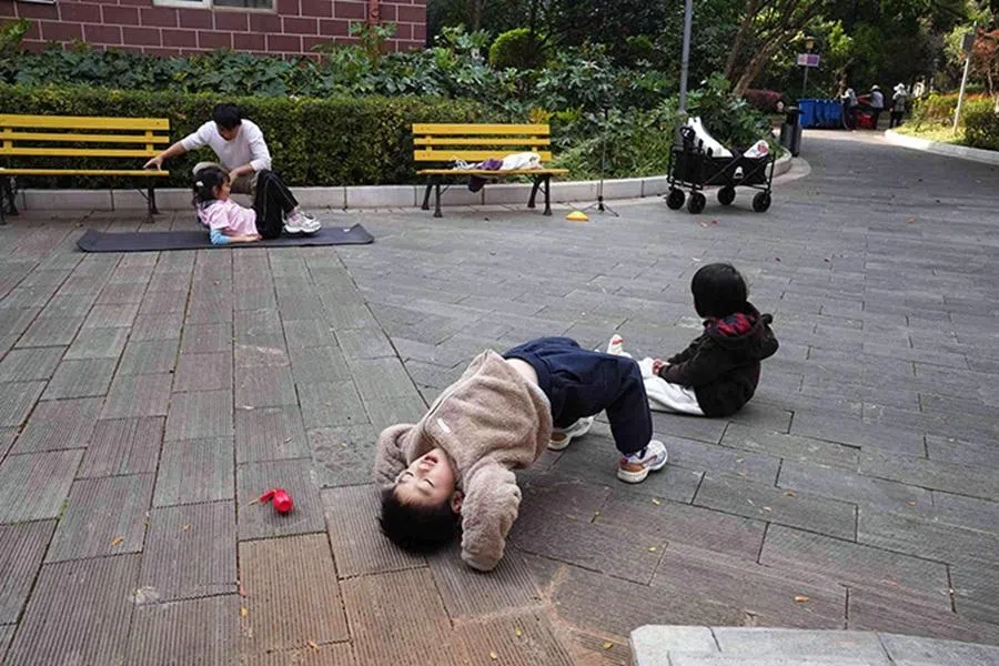 A neighbourhood child mimics Huang Tingshun’s student during a training session.