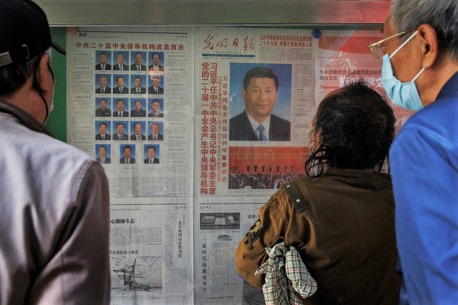 People read a newspaper covering the 20th Party Congress of the Communist Party of China at a public display stand in Beijing, China, 24 October 2022. (Thomas Peter/Reuters)