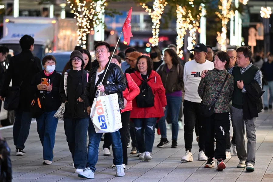 A Chinese tour group walks in the Ginza shopping district in Tokyo on 17 November 2025. (Greg Baker/AFP)
