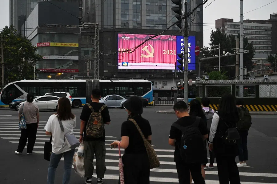 People wait to cross a road in Beijing, China, on 29 June 2021. (Greg Baker/AFP)
