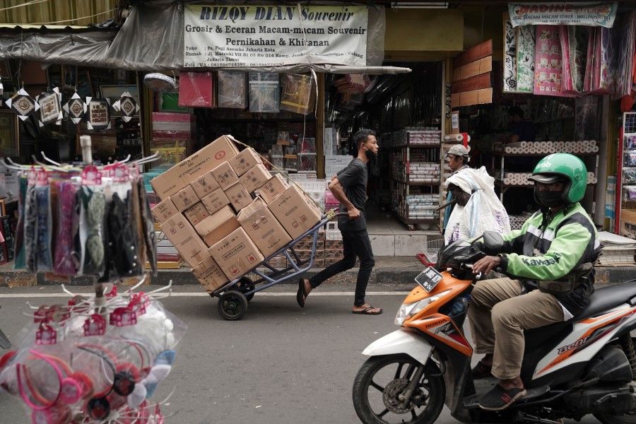A porter transports boxes at Asemka Market in Jakarta, Indonesia, on 15 March 2021. (Dimas Ardian/Bloomberg)