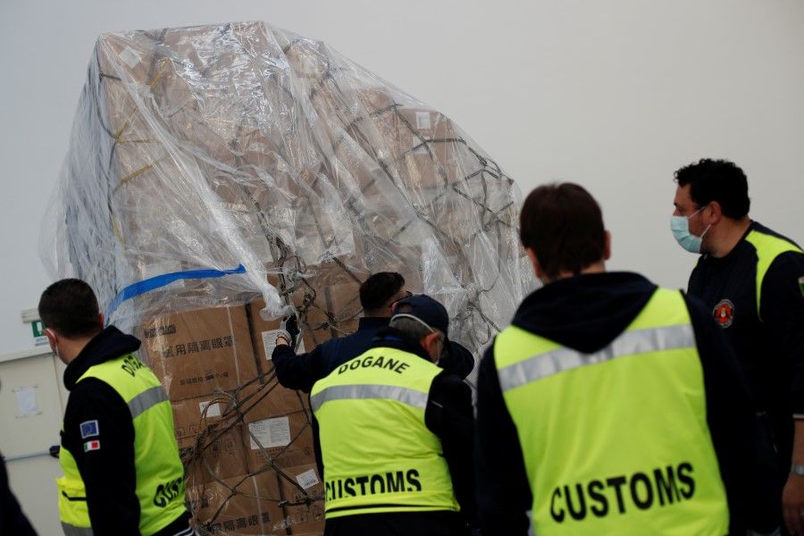 Customs officers inspect a shipment containing supplies of personal protective equipment (PPE) at Bari airport after arriving from Guangzhou, April 7, 2020. (Alessandro Garofalo/REUTERS)