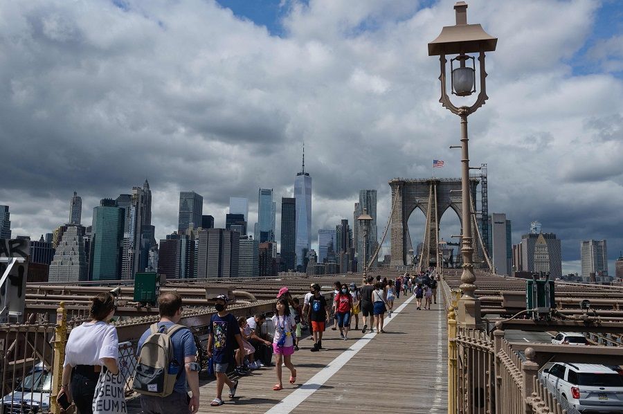 People walk over the Brooklyn Bridge from Manhattan in New York City, US on 19 August 2021. (Angela Weiss/AFP)