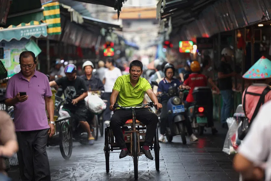 A man rides a tricycle at a market in Haikou, Hainan province, China, on 6 May 2024. (AFP)