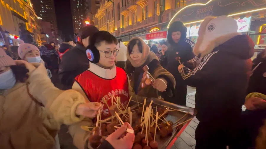 A Harbin enterprise offers free food to tourists at Zhongyang Pedestrian Street. (Photo: Daryl Lim)