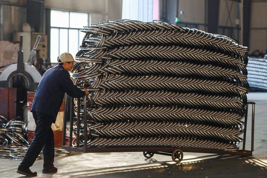 A worker pushes a cart of steel rims at a factory producing bicycle parts for export in Hangzhou, in eastern China’s Zhejiang province on 18 February 2024. (AFP)
