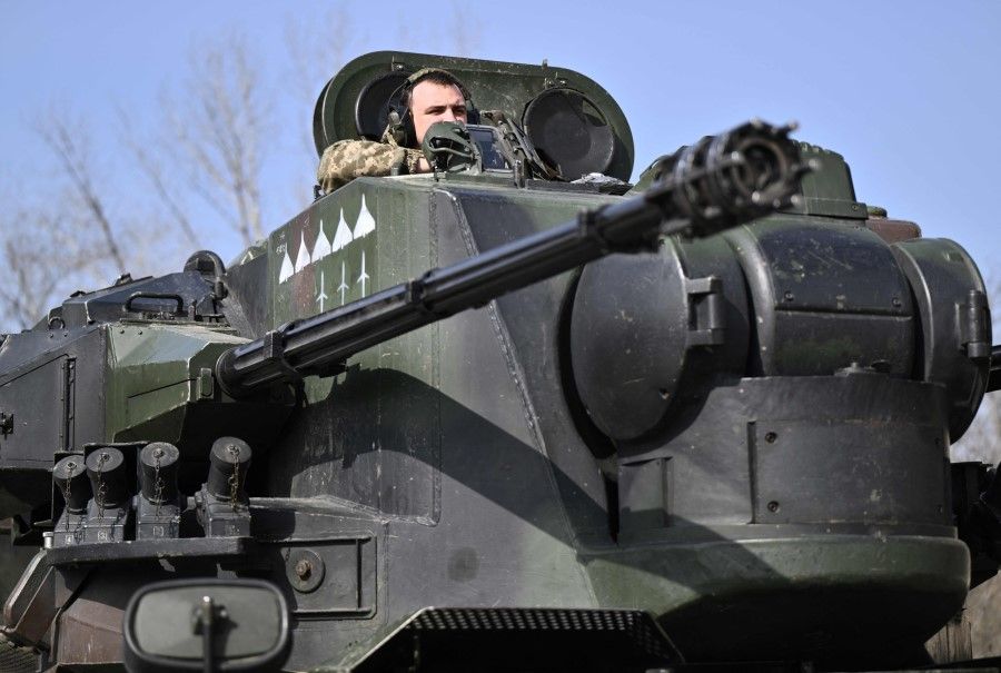 A Ukrainian serviceman, crew member of a German-made self-propelled anti-aircraft (SPAAG), better known as the Flakpanzer Gepard, prepares for combat duty in the Kyiv region, on 21 March 2024, amid the Russian invasion of Ukraine. (Genya Savilov/AFP)