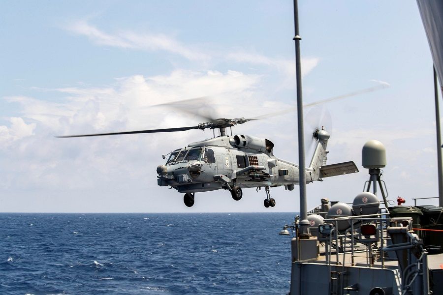 A Royal Australian Navy MH-60R Seahawk helicopter takes off from HMAS Parramatta during a South China Sea transit, in this 14 April 2020 handout photo. (Australia Department Of Defence/Handout via Reuters)
