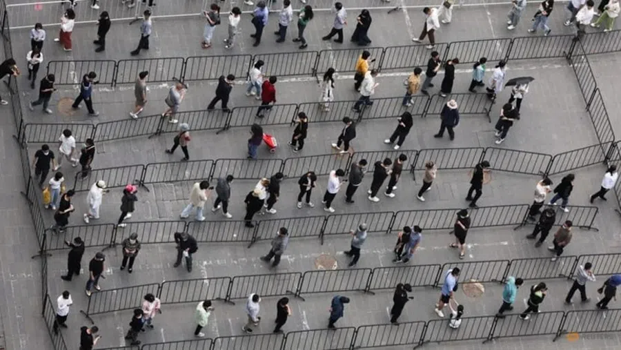 Residents line up at a makeshift nucleic acid testing site during a mass testing for Covid-19 following the outbreak, in Beijing, China on 25 April 2022.