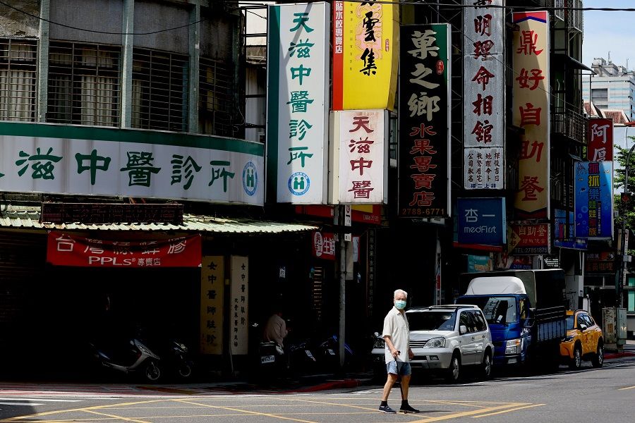 A man crosses the street while wearing a protective mask in Taipei, Taiwan, 2 June 2021. (Ann Wang/Reuters)