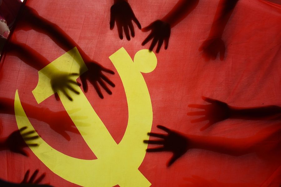 School children place their hands on the Communist Party flag during a class about the history of the Communist Party at a school in Lianyungang, Jiangsu, China, on 28 June 2020. (STR/AFP)
