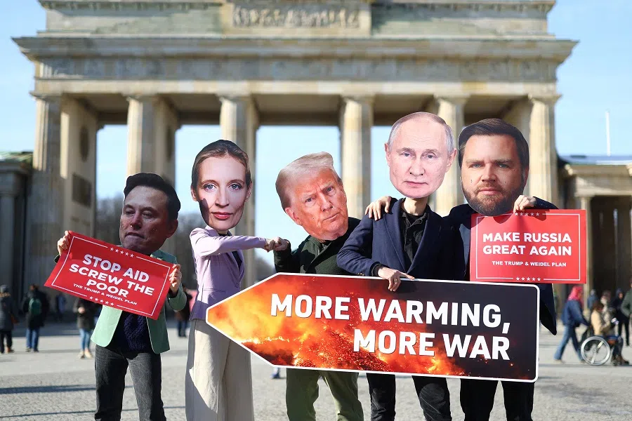 People wearing head cut-outs depicting U.S. President Donald Trump, US Vice-President JD Vance, Elon Musk, Russian President Vladimir Putin and Alternative for Germany (AfD) party co-leader Alice Weidel hold placards during a protest at the Brandenburg Gate in Berlin, Germany, on 20 February 2025. (Lisi Niesner/Reuters)