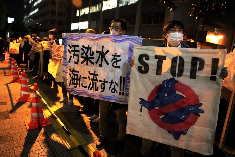 Protestors hold slogans as they take part in a rally against the Japanese government's decision to release treated water from the stricken Fukushima Daiichi nuclear plant into the ocean, outside of the prime minister's office in Tokyo, Japan, on 13 April 2021. (Yuki Iwamura/AFP)