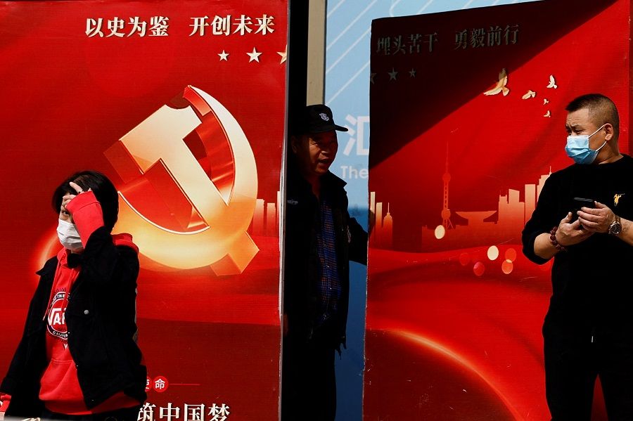 A security guard opens a door attached with a poster welcoming the 20th Party Congress of the Communist Party of China, in Beijing, China, 14 October 2022. (Tingshu Wang/Reuters)