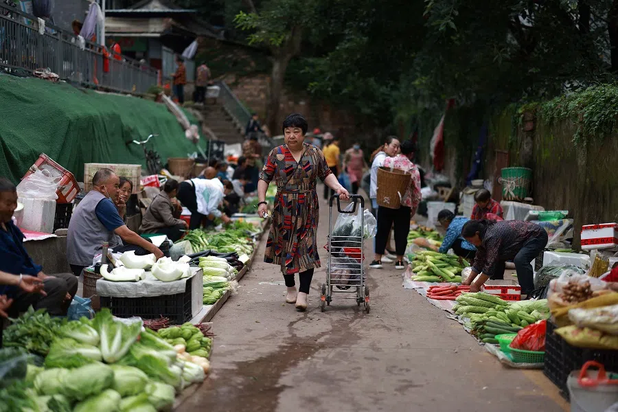 A customer buys vegetables at a market in Ya'an in Sichuan province, China, on 9 September 2021. (STR/AFP)
