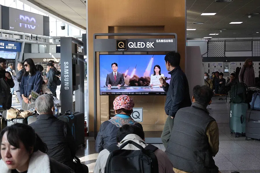 People sit near a television showing a news broadcast with file footage of a North Korean missile test, at a railway station in Seoul on 5 November 2024. (Anthony Wallace/AFP)