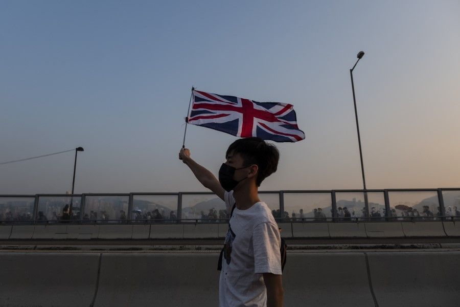 A demonstrator waves a Union Jack during a protest in Hong Kong. The people of Hong Kong seem to no longer consider mainland China family. (Chan Long Hei/Bloomberg)