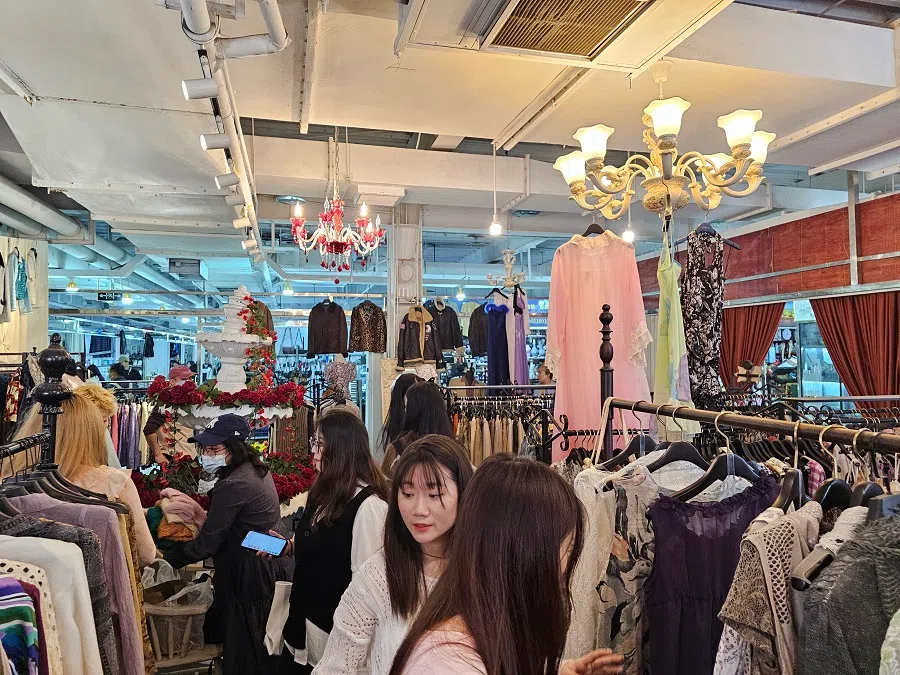 Young people browsing through second-hand apparel at the Dongjiaxi flea market in Chongqing. 