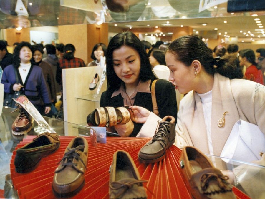 Young women shop for new styles of shoes at stores on the Bund in Shanghai, 1994.