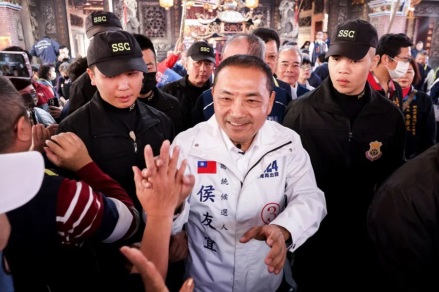 Hou Yu-ih (centre), presidential candidate from the main opposition Kuomintang (KMT), shakes hands with supporters at a local temple during a visit as part of his election campaign in New Taipei City on 5 January 2024. (I-Hwa Cheng/AFP)