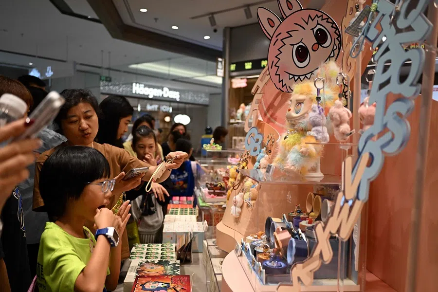 People check out newly-launched mini Labubu toys at a Pop Mart shop in Beijing on 29 August 2025.
