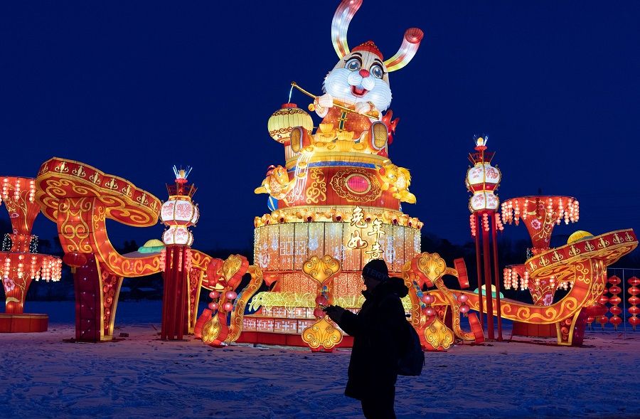 This photo taken on 29 December 2022 shows a person visiting a lantern show ahead of the new year in Shenyang, Liaoning province, China. (AFP)