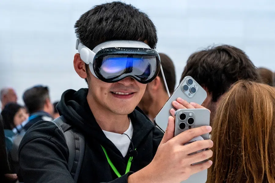 An attendee wearing an Apple Vision Pro with the Apple iPhone 16 Pro during an event at Apple Park campus in Cupertino, California, US, on 9 September 2024. (David Paul Morris/Bloomberg)