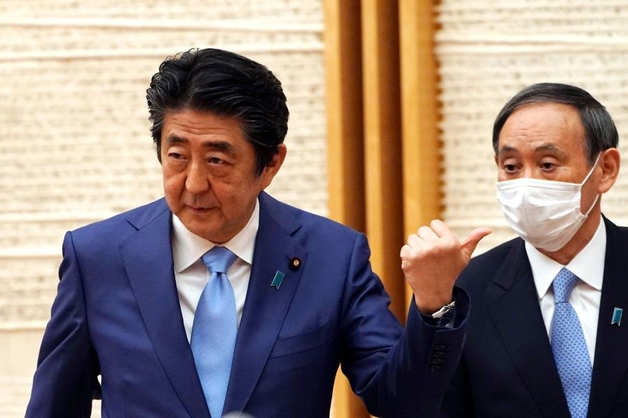 Japanese Prime Minister Shinzo Abe (L) with Yoshihide Suga, Chief Cabinet Secretary, during a press conference at the prime minister's office in Tokyo, 4 May 2020. (Eugene Hoshiko/AFP)