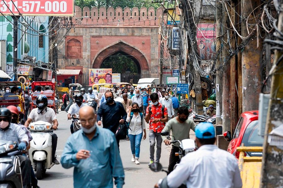 People make their way along a street in the old quarters of New Delhi on 7 August 2020. (Jewel Samad/AFP)